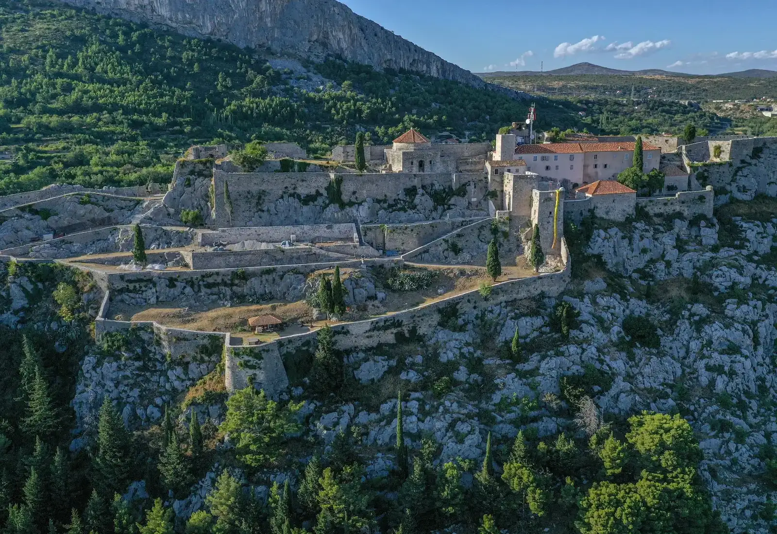Tour group exploring Klis Fortress courtyard