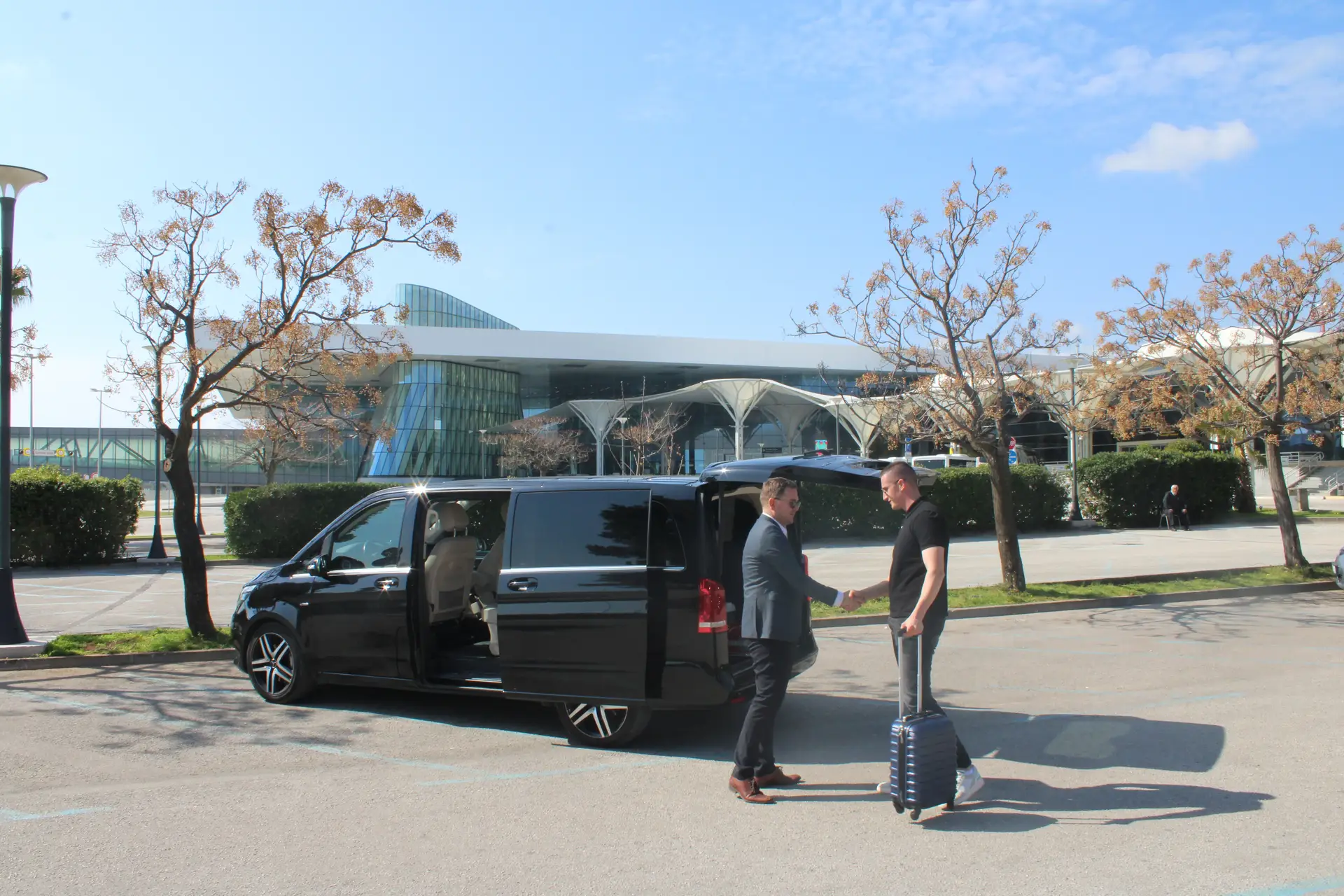 two men holding hands at airport